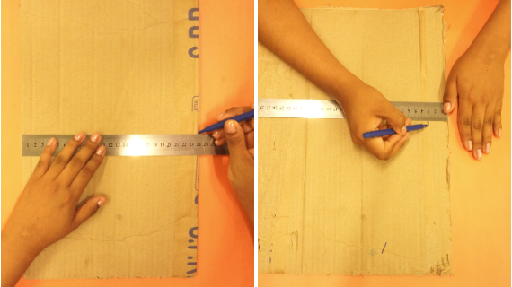 Foto de um papelão, uma régua e uma caneta