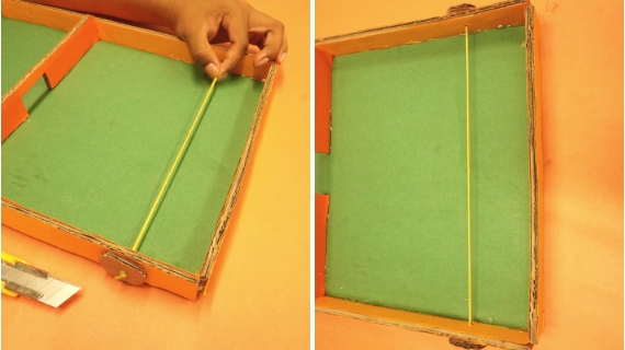 Foto do tabuleiro de papelão com um elástico no meio