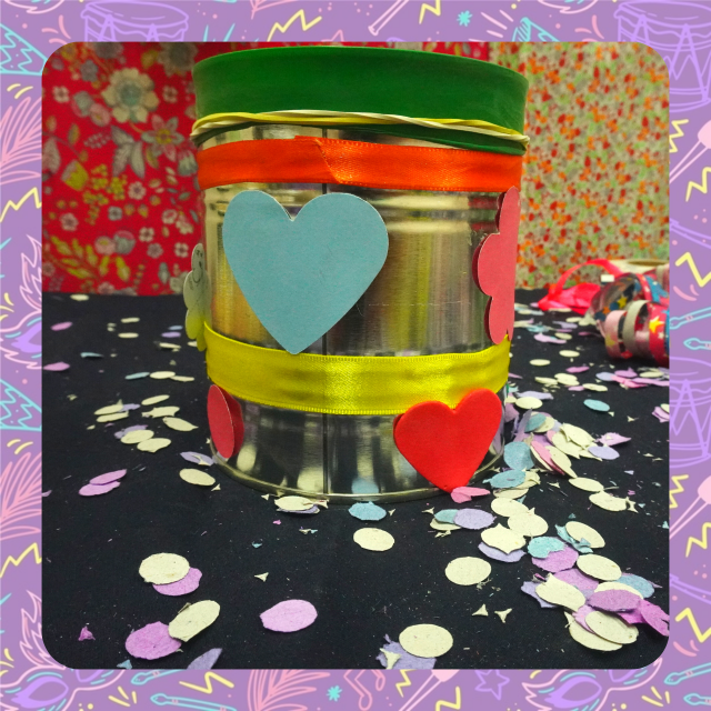 Fotografia de um tambor feito de lata e enfeitado com papel recortado em fortma de coração