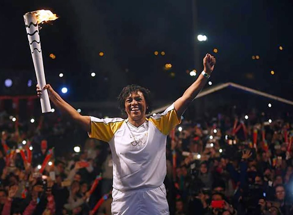 Jogadora Marileia segurando a pira Olímpica