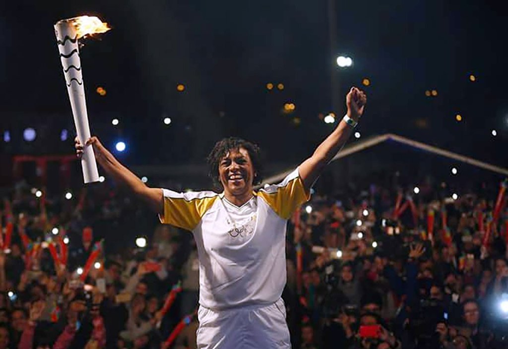 Jogadora Marileia segurando a pira Olímpica