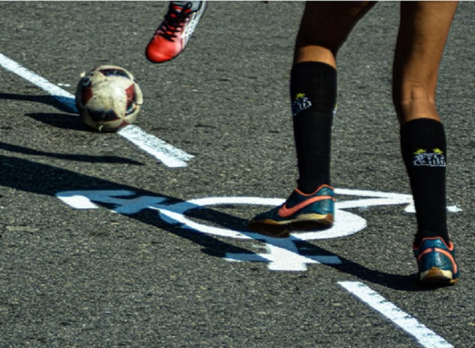 Imagem de um símbolo de gênero e pés com chuteiras