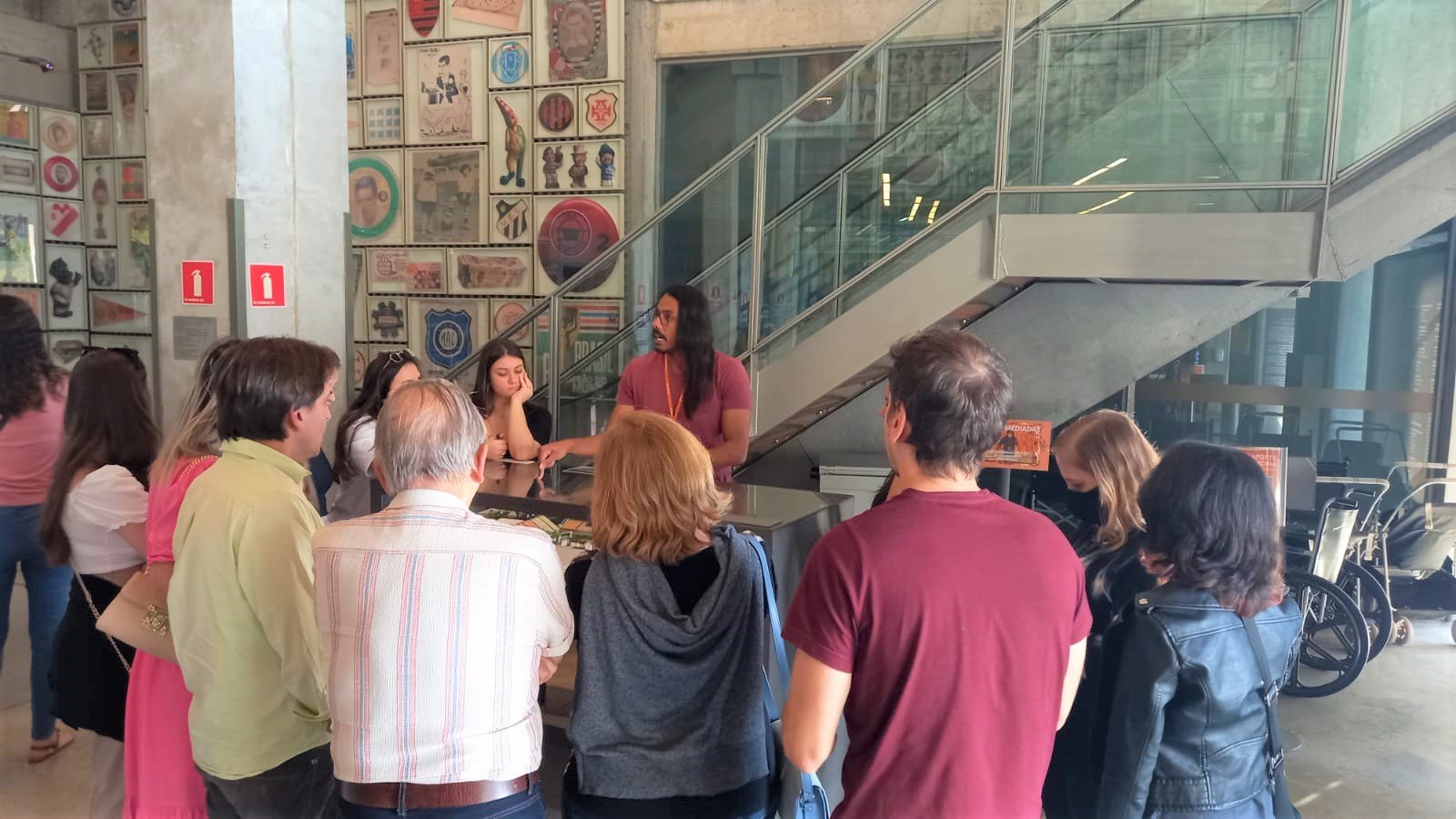 Grupo de pessoas ao redor de um educador do museu