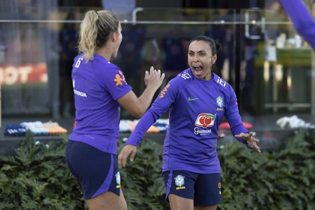 Tamires e Marta com uniformes de treino comemoram um gol