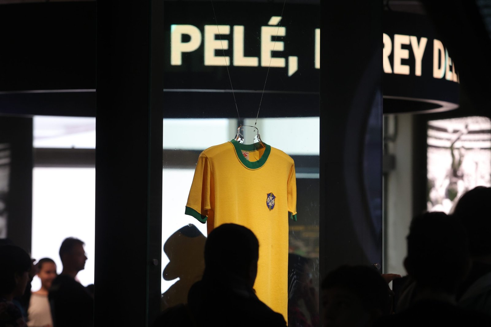 A camisa amarela de Pelé aparece ao fundo da imagem. Sobre ela, se lê um letreiro escrito "Pelé"