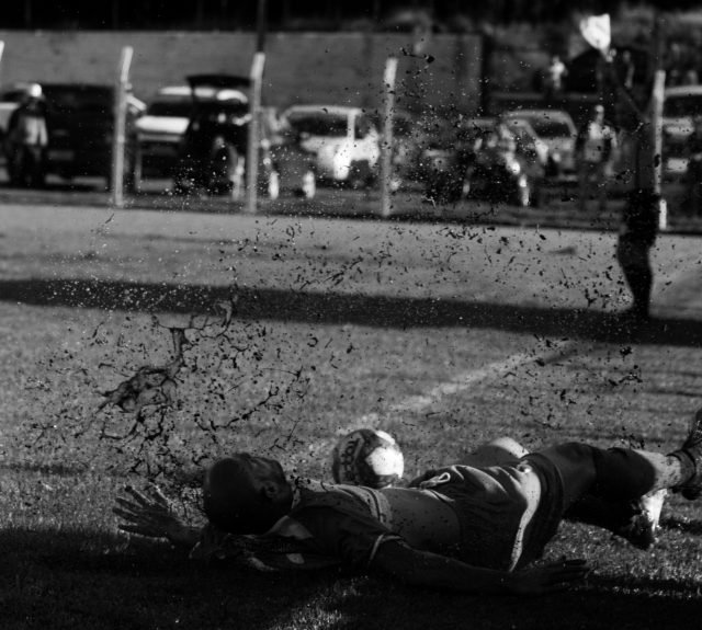 CarlitosCleversonMarinho Imagem em preto e branco. Nela o goleiro faz sua defesa. A lama se espalha mas o gol não entra.