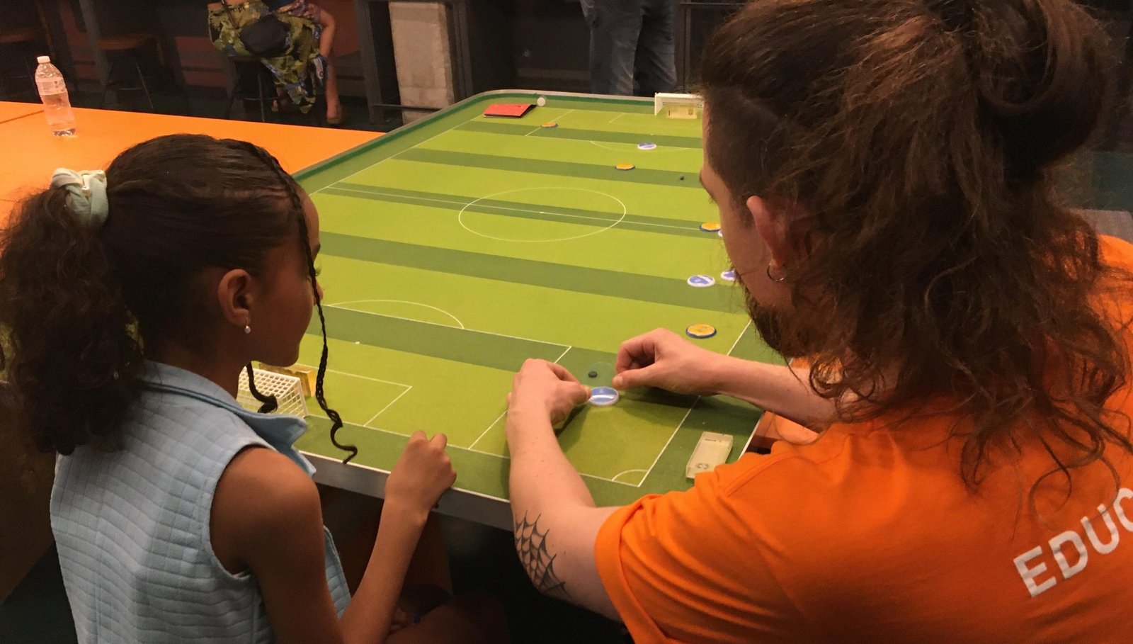 Imagem de um educador com uma criança fazendo a atividade