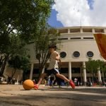 Imagem de uma criança chutando uma bola na área externa do Museu do Futebol