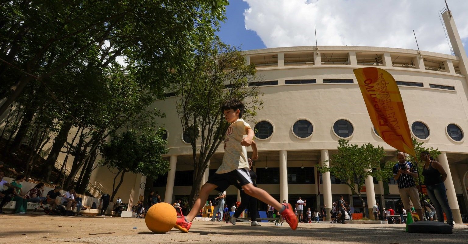 Imagem de uma criança chutando uma bola na área externa do Museu do Futebol