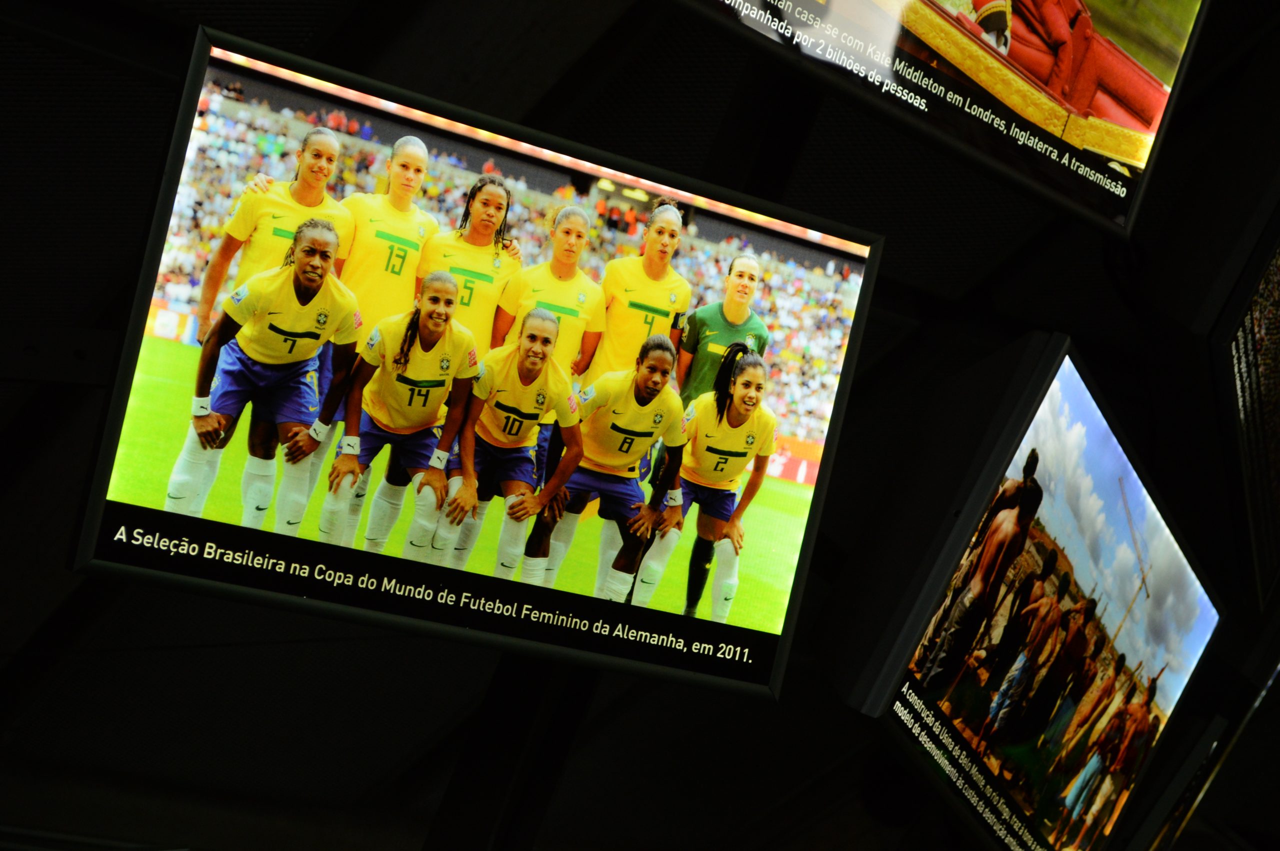 Fotografia de uma imagem da Sala Copas do Mundo que mostra a Seleção Brasileira Feminina de Futebol, em pose do grupo antes de iniciar uma partida.