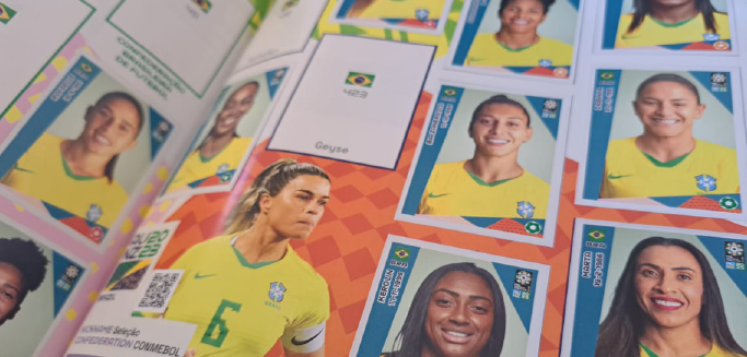 Foto da página da seleção brasileira do futebol feminino do álbum de figurinhas da Copa do Mundo de 2023. Aparecem algumas jogadoras famosas como Marta, Debinha, Tamires e Bia Zaneratto.