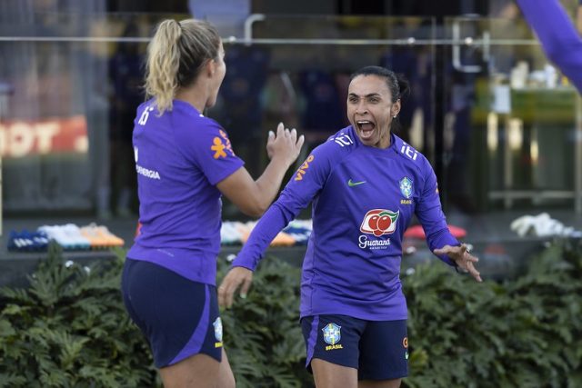 Tamires e Marta com uniformes de treino comemoram um gol