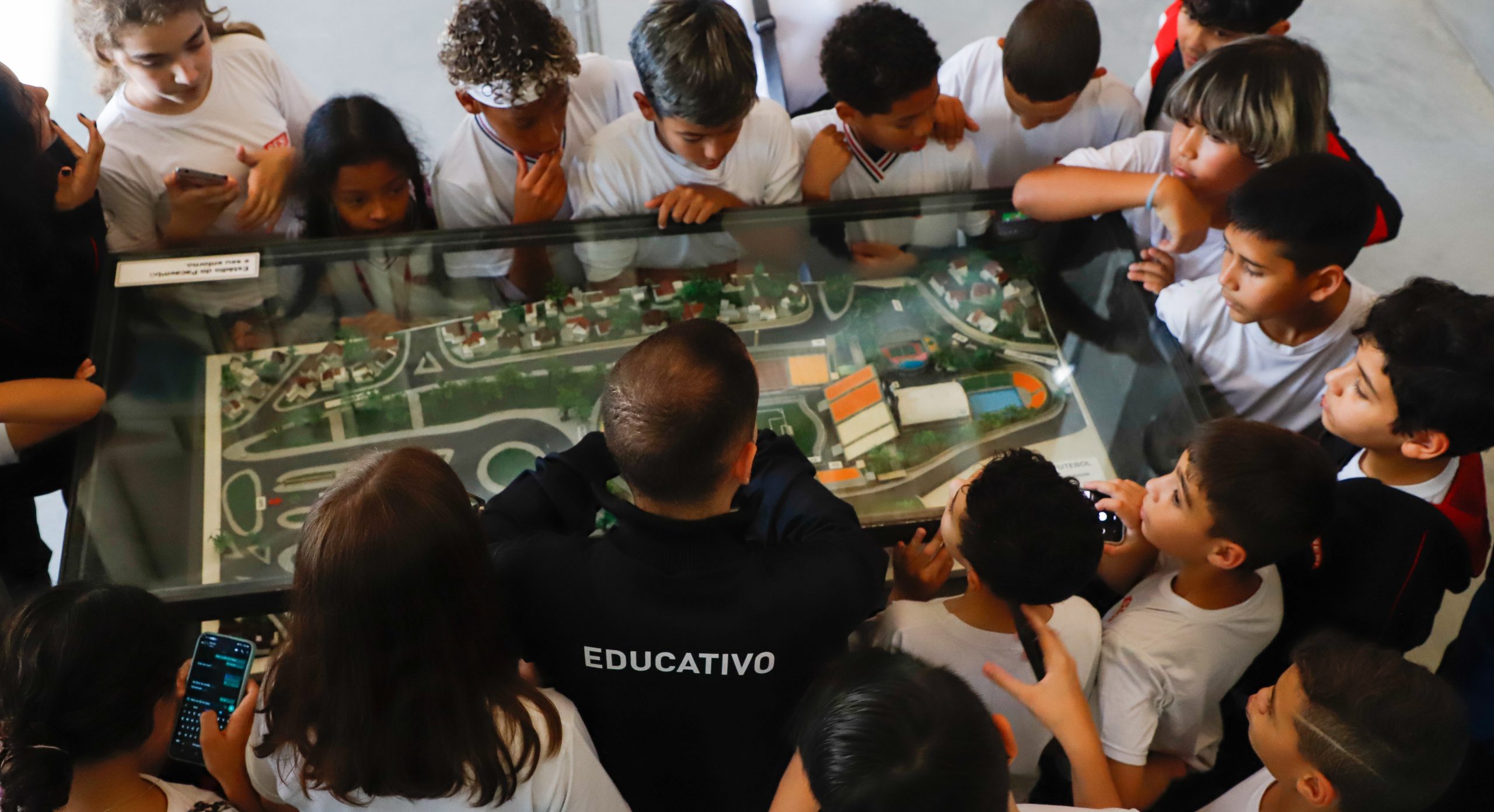 Imagem com o profissional do educativo e visitantes no museu