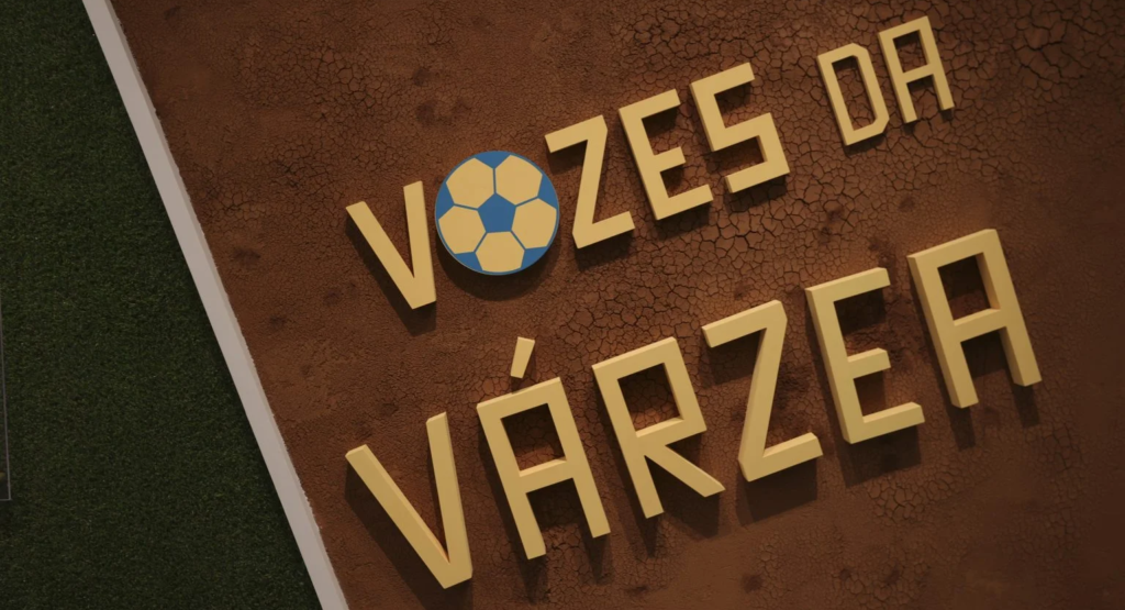 Painel de entrada da exposição com a marca Vozes da Várzea sobre um fundo de terra seca.