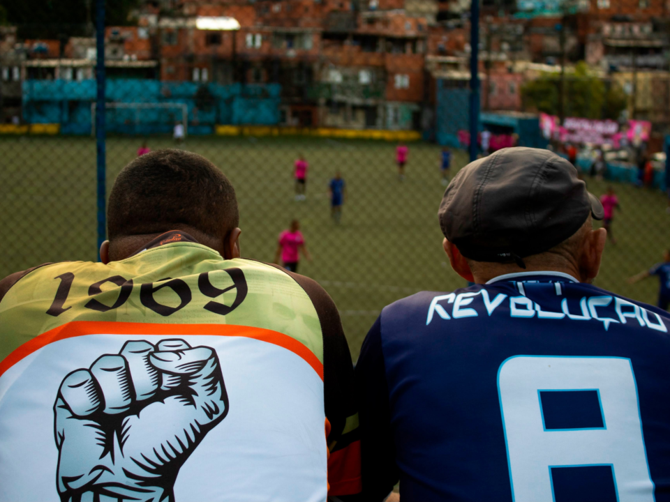 Torcedores de gerações distintas assistem à partida de futebol de várzea, Taboão da Serra-SP.