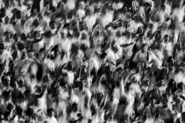 Arte de torcer A foto em preto e branco registra uma torcida em movimento - por isso, a imagem é levemente borrada.