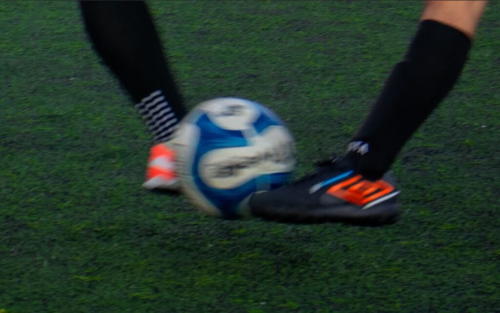 imagem de disputa de bola. mostra só os pés e meias pretas