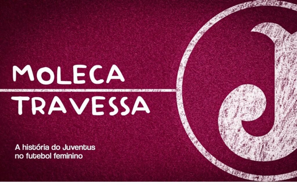 cartaz com os dizeres Moleca Travessa. Fundo vinho, como se fosse um gramado de campo