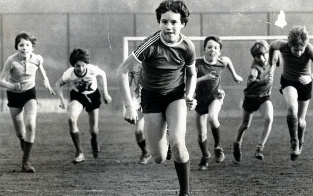 Fotos em Pe B de meninas correndo em um campo de futebol