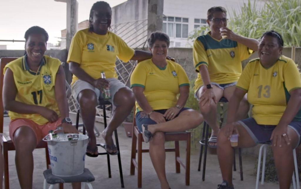 foto de quatro mulheres sentadas vestindo a camisa da seleção brasileira
