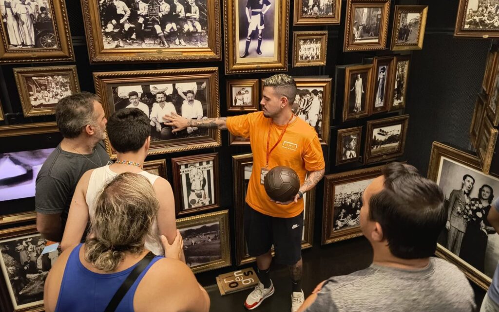 foto registrada na sala origens. pessoa do tome do educativo segura uma bola e atende ao publico