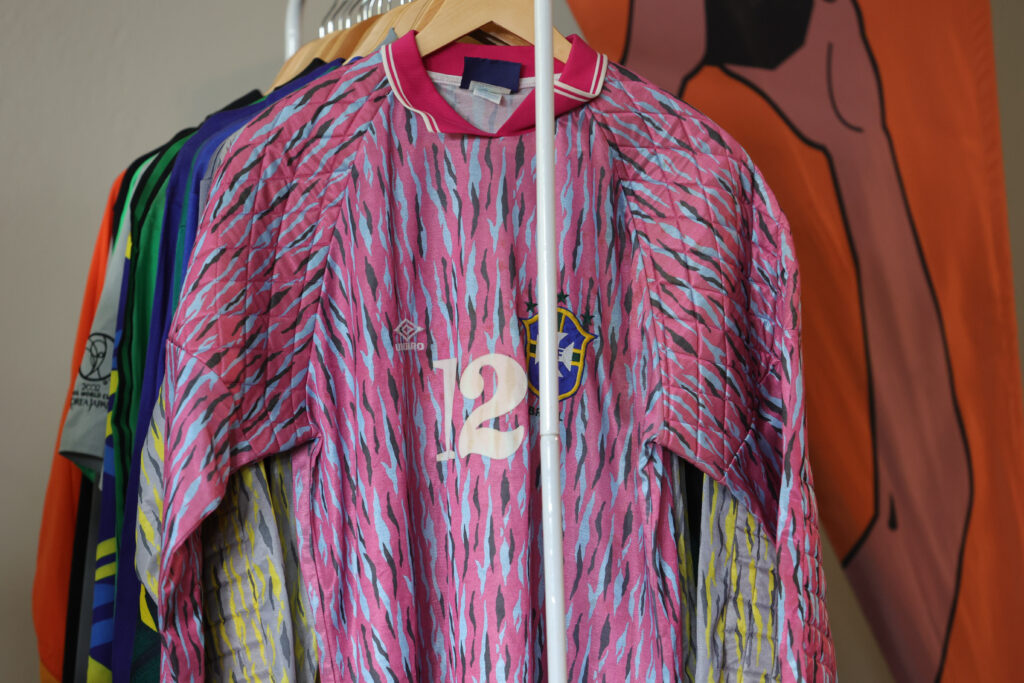 varal de camisas. na frente, uma camisa de goleiro, cor de rosa.