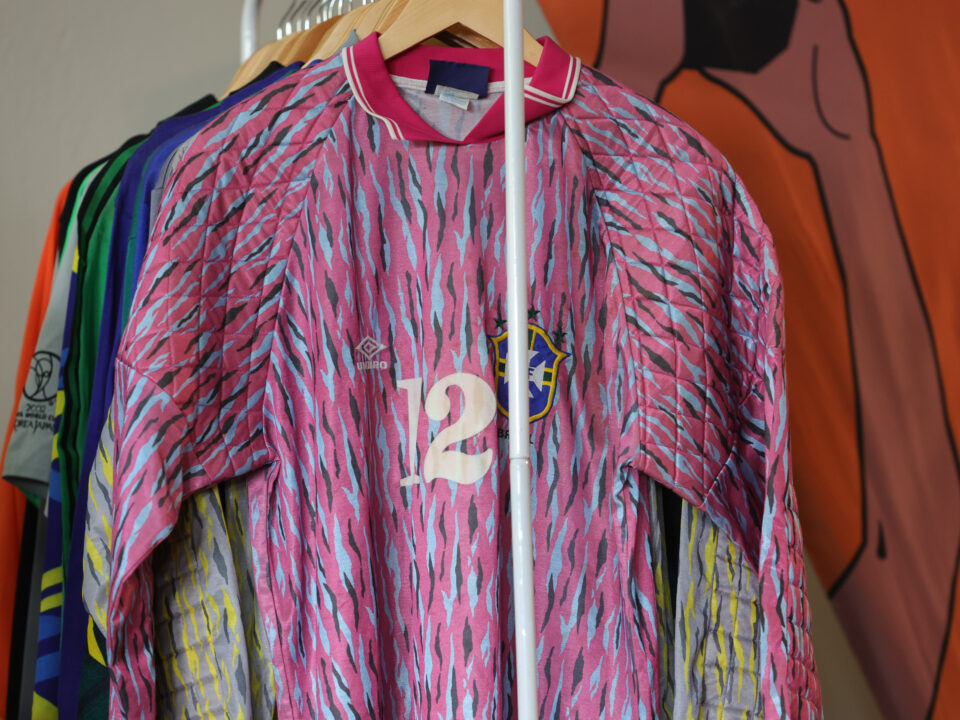 varal de camisas. na frente, uma camisa de goleiro, cor de rosa.