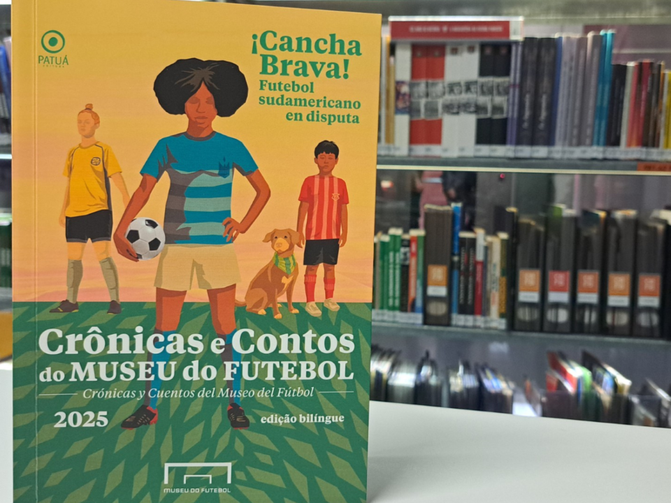 Capa do Livro do Concurso de Cronicas. A capa tem um fundo amareo, com tres pessoas em desenho. No centro uma jogadora segura uma bola e veste azul.